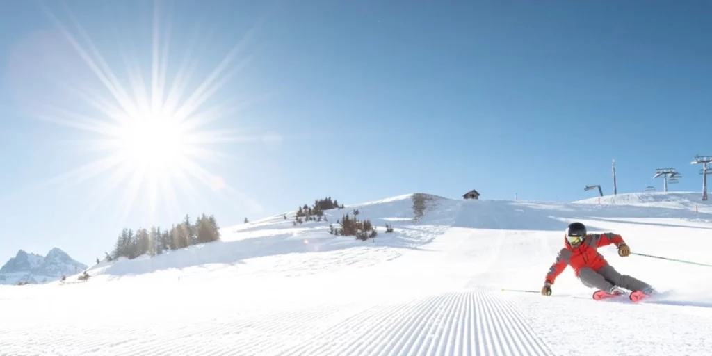 Skieur sur une piste damée au soleil